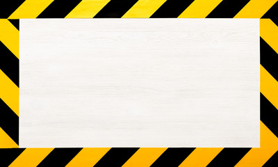 under construction concept background. warning tape frame on white wooden surface background with co