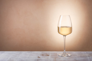 glass with white wine on table