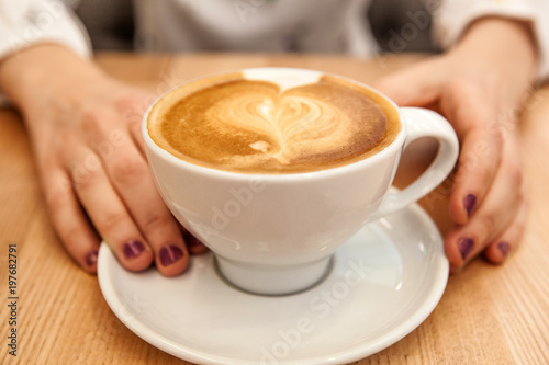 Plakat kubek cappuccino z pianką w kształcie serca i rąk