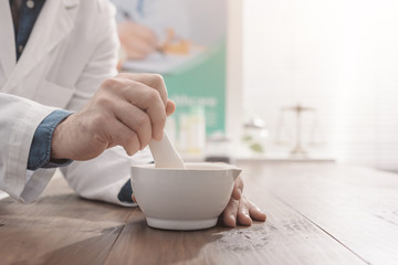 Wall Mural - Pharmacist grinding a preparation using a pestle