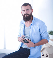 Wall Mural - Portrait of male designer in hat with blueprints at desk 