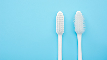 The old toothbrush and new toothbrush on a blue background.