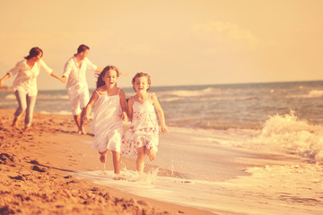 Wall Mural - happy family playing with dog on beach