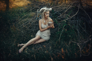 Beautiful model is posing in a forest with white horns 