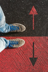 Concept of facing a crucial decision about which direction to go shown by shoes on different colored pathways