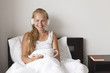 © AnastazjaSoroka - Happy morning. Young woman listen music in white bed.
