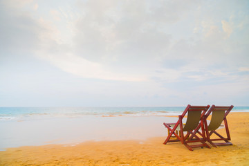 Two beach chairs on the beach.