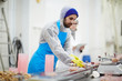 © pressmaster - Young man in protective uniform working by production-line in seafood processing factory