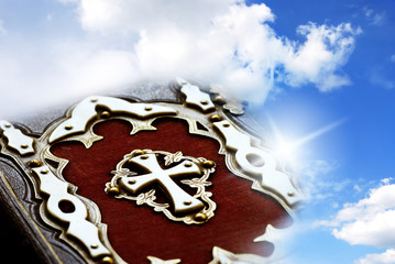 Wall Mural - christian catholic bible with cross over cloudy sky