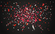 Colorful confetti and ribbons on dark background