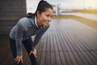 © Flamingo Images - Smiling young Asian woman resting while out jogging