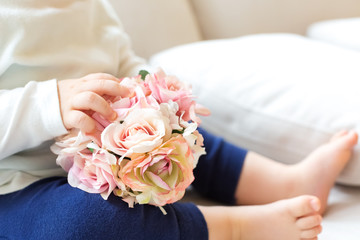 Toddler boy with spring flowers on a couch