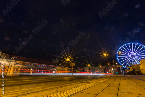 Plakat Riesenrad und Lichtspuren vorbeifahrender Autos in Potsdam bei Nacht