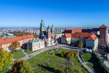 Fototapeta  - Royal Wawel Gothic Cathedral in Cracow, Poland, with Renaissance Sigmund Chapel with golden dome, part of Wawel Castle, yard, park and tourists. Aerial view in the morning