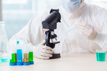 Young chemist student working in lab on chemicals