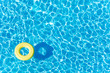 Empty rubber ring floating on blue water surface