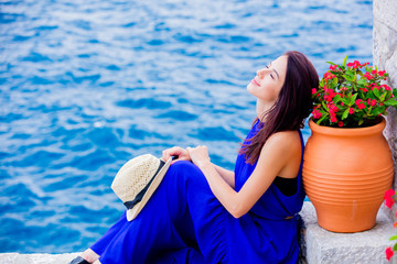 Young girl in blue dress in city of Hydra island in Greece. Summertime vacation concept