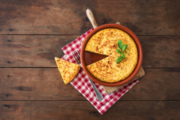 Wall Mural - Spanish potato omelet called tortilla de patatas on a rustic wooden texture with a place for text.