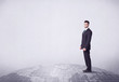 © ra2 studio - An elegant young male businessman standing on top of the world, pointing up concept with drawn earth map.
