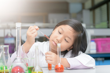 Wall Mural - student in lab coat making experiment with test tube
