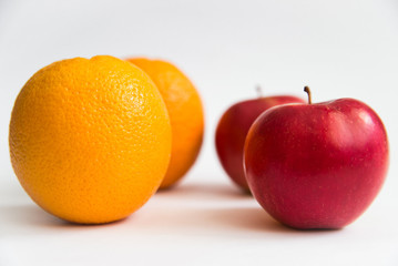 Isolated fruits. Cut red apples and orange fruits isolated on white background 