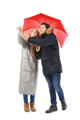 Poster - Young romantic couple with bright umbrella on white background