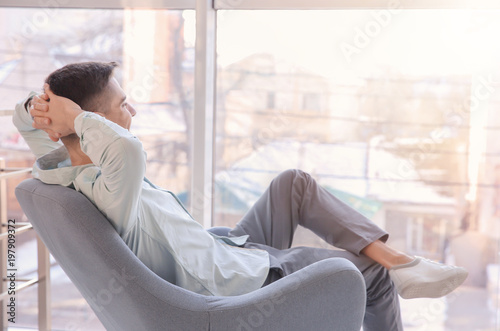 Fotomural Young man resting in armchair. Joy of life