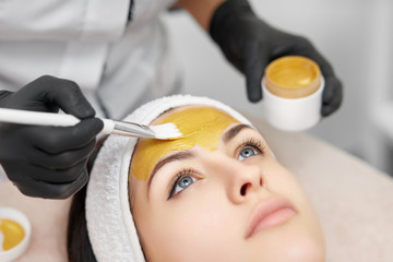 Gorgeous woman enjoying mask procedures in beauty salon.