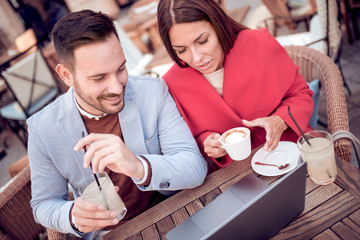 Canvas Print - Couple is sitting at cafe and using a laptop