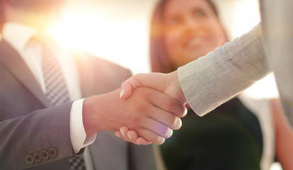 Wall Mural - Businesspeople  shaking hands against room with large window loo