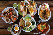 Many Kind Of Sea Food And Thai Food On Wooden Table