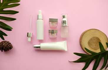 natural cosmetic makeup , organic skincare with wood and leaves, flat lay on pink background.