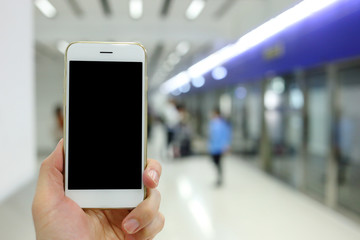 Poster - Hand holding white mockup smartphone with subway station background