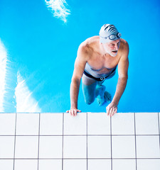 Wall Mural - Senior man in an indoor swimming pool.