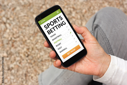 Fotografía Hand holding smart phone with sports betting concept on screen