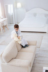 Wall Mural - First patient. Top view of adorable appealing sincere boy playing with plush bear while treating it and wearing uniform