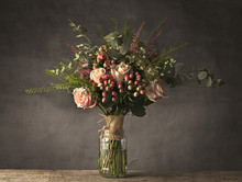 Bouquet Of Pink Roses In A Jam Jar On A Wooden Table