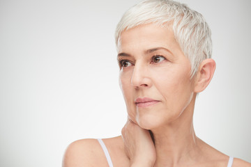 Portrait of beautiful senior woman in front of white background.