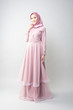 © Apiq Sulaiman - Attractive young Muslim girl wearing pink dress and hijab with grey background.Hijab Fashion Portraiture.
