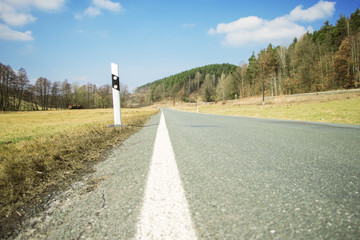 Road with reflector post at a cloudy spring day