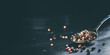 Bunter Pfeffer gehäuft auf einem Löffel auf dunklem Untergrund und dunklem Hintergrund Nahaufnahme bei Gegenlicht fotografiert
