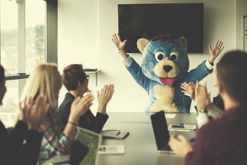 Wall Mural - boss dresed as bear having fun with business people in trendy office