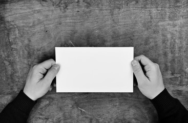 Canvas Print - monochrome photo male hands holding a white blank sheet of paper