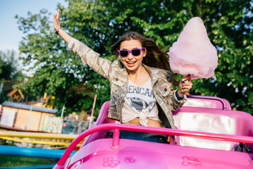 Wall Mural - Stylish girl riding a roller coaster at the park