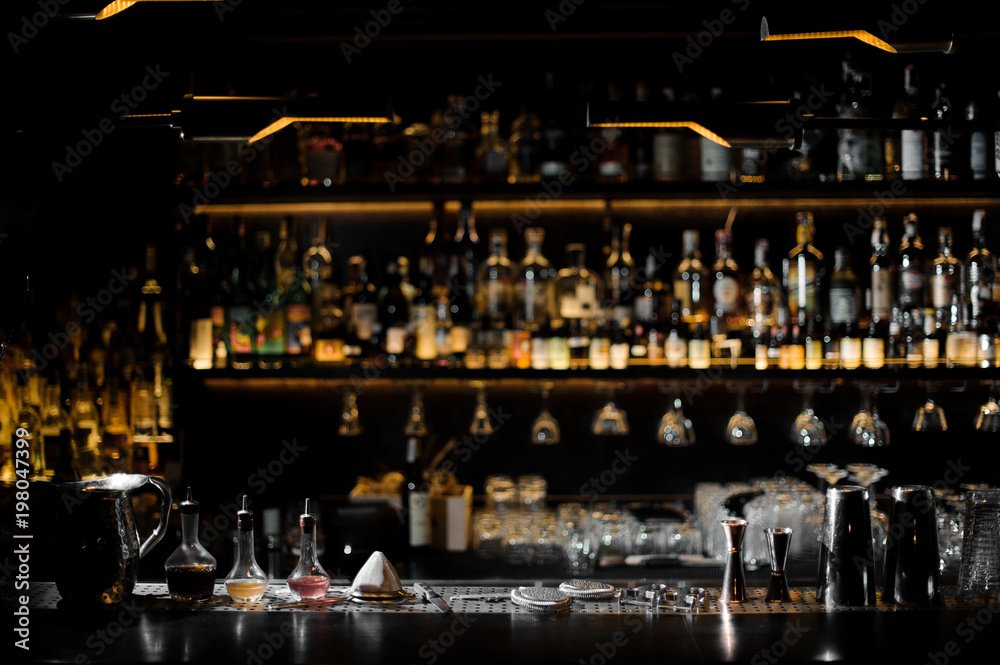 Blurred background of dark bar with barman essentials - obrazy, fototapety, plakaty 