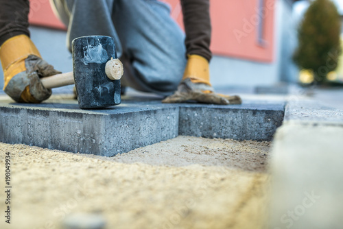 Fotografía Workman tamping down a new paving brick