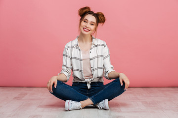 Canvas Print - Portrait of a happy young girl sitting on a floor