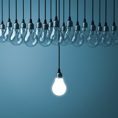 Fototapete - Stand out from the crowd and different creative idea concepts , One hanging light bulb glowing with unlit incandescent bulbs on dark cyan background , 3D rendering.