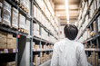 © zephyr_p - Young Asian man standing in warehouse choosing what to buy