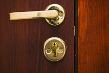 Door Handle Gold Color With A Lock On Wooden Door